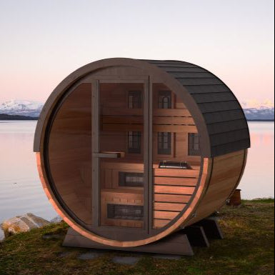 Barrel sauna on grass by the ocean