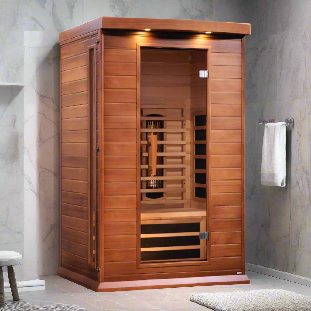 A 2-person full spectrum infrared sauna made from Canadian Red Cedar, featuring a bamboo mat floor, wooden benches, and a glass door.