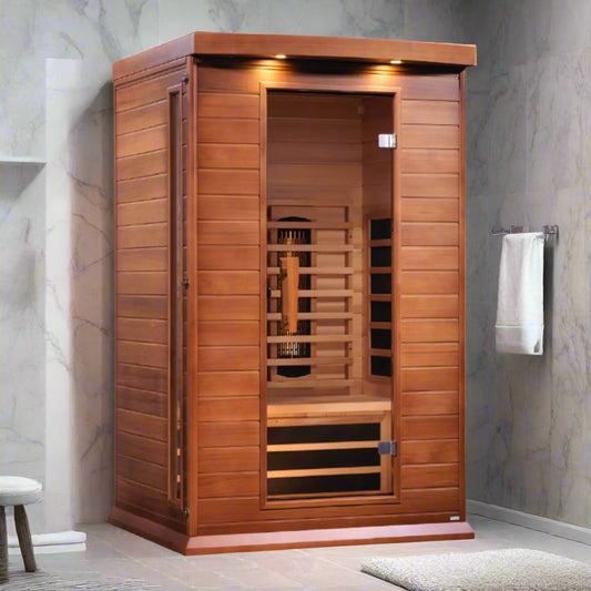 A 2-person full spectrum infrared sauna made from Canadian Red Cedar, featuring a bamboo mat floor, wooden benches, and a glass door.