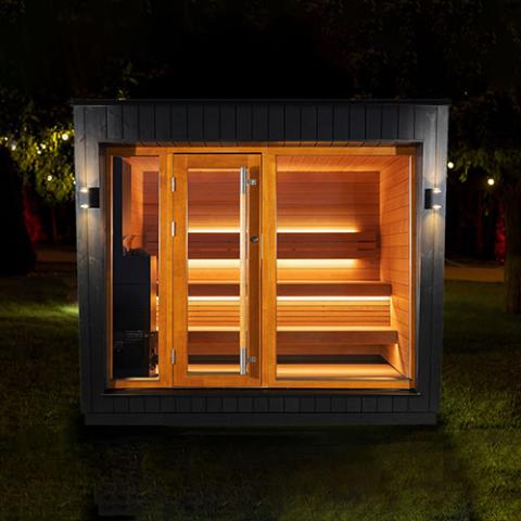 Saunum AirCube Space Outdoor Sauna at night with lights on