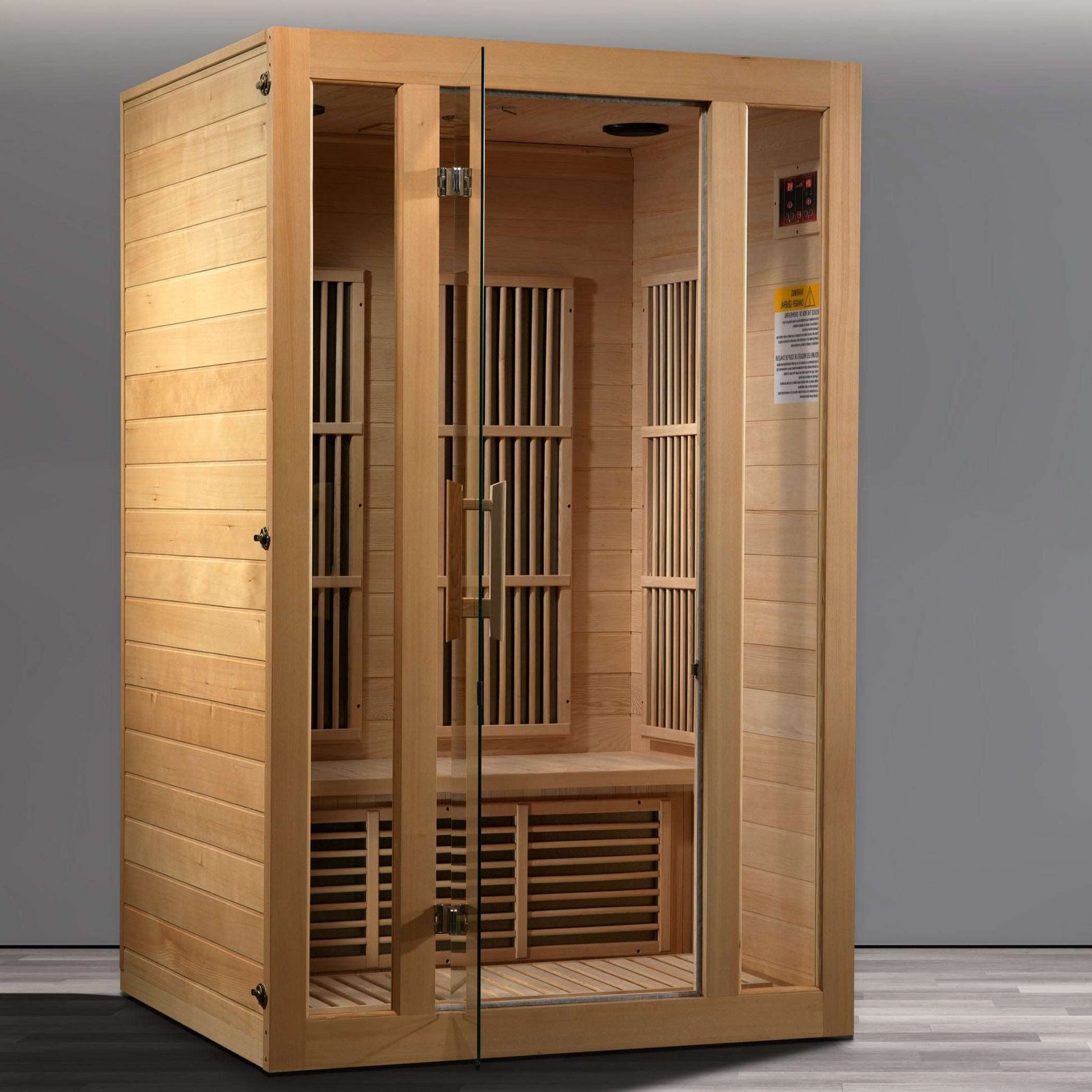 A Maxxus Seattle 2 Person Low EMF Far Infrared Sauna made of Hemlock wood with a glass door and side windows, featuring an interior bench and heating panels.