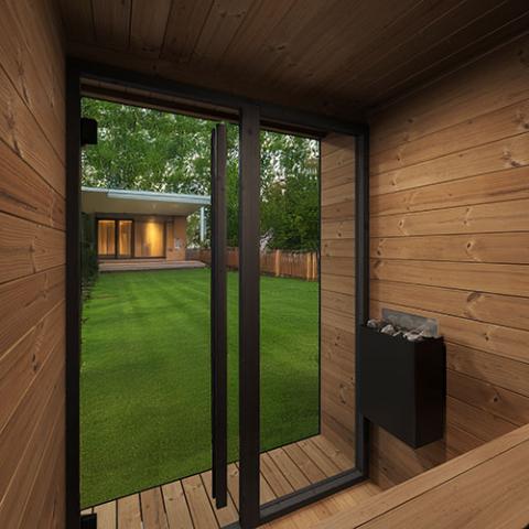 Wooden cabin sauna interior with a view of a garden through glass doors.