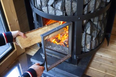 Loading firewood into the Harvia Legend 240 GreenFlame