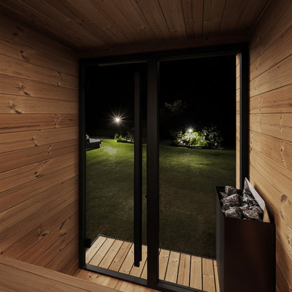 Wooden sauna interior with a view of a garden at night