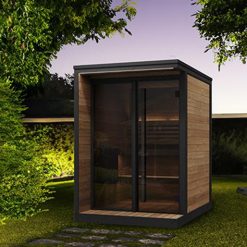 Small outdoor traditional sauna on grass in backyard